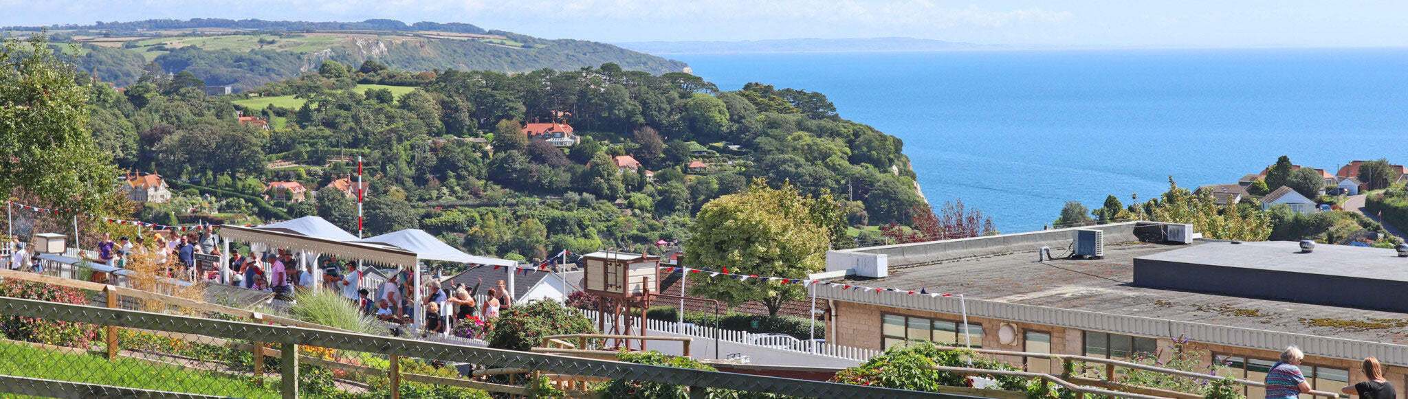 Panoramic view of Beer from Pecorama, a coastal town with greenery and a clear sky.